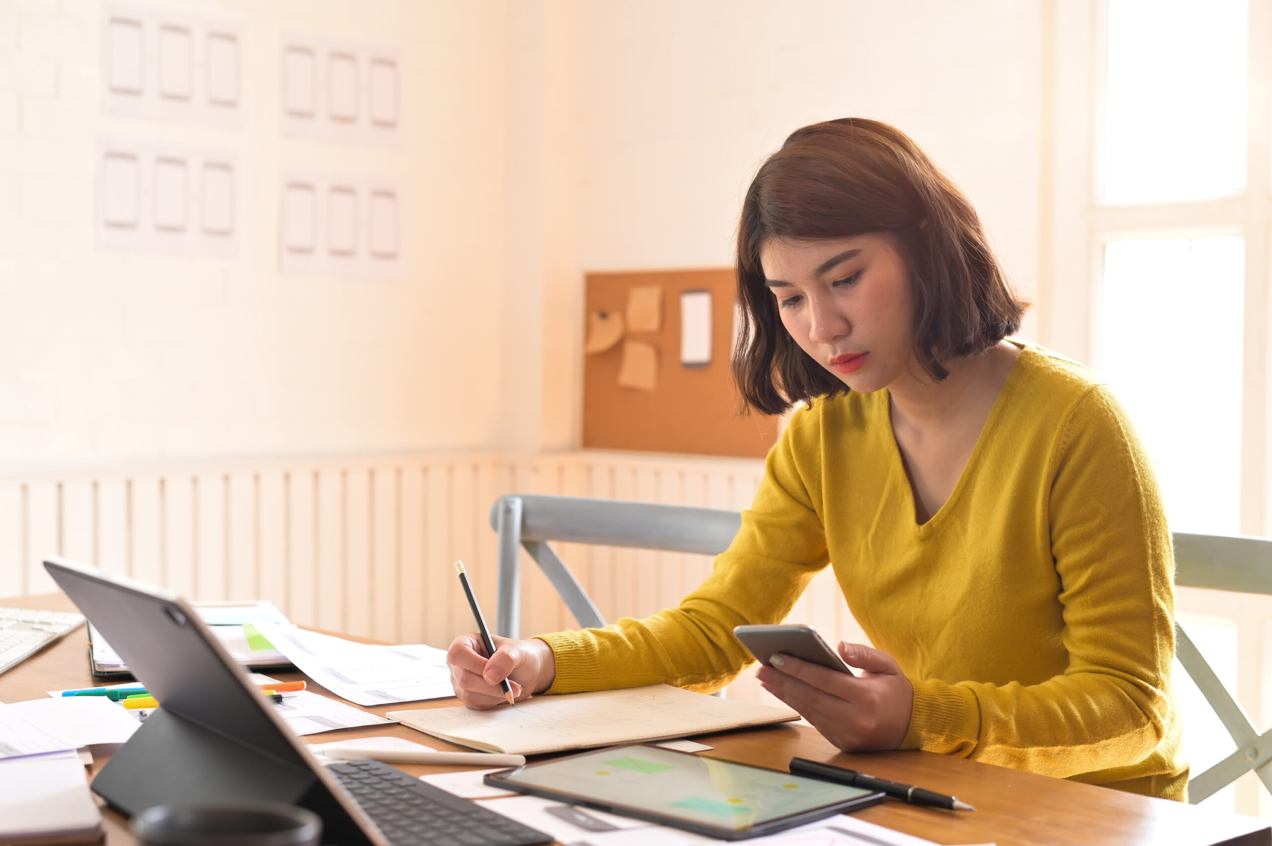 person working with project taking notes.